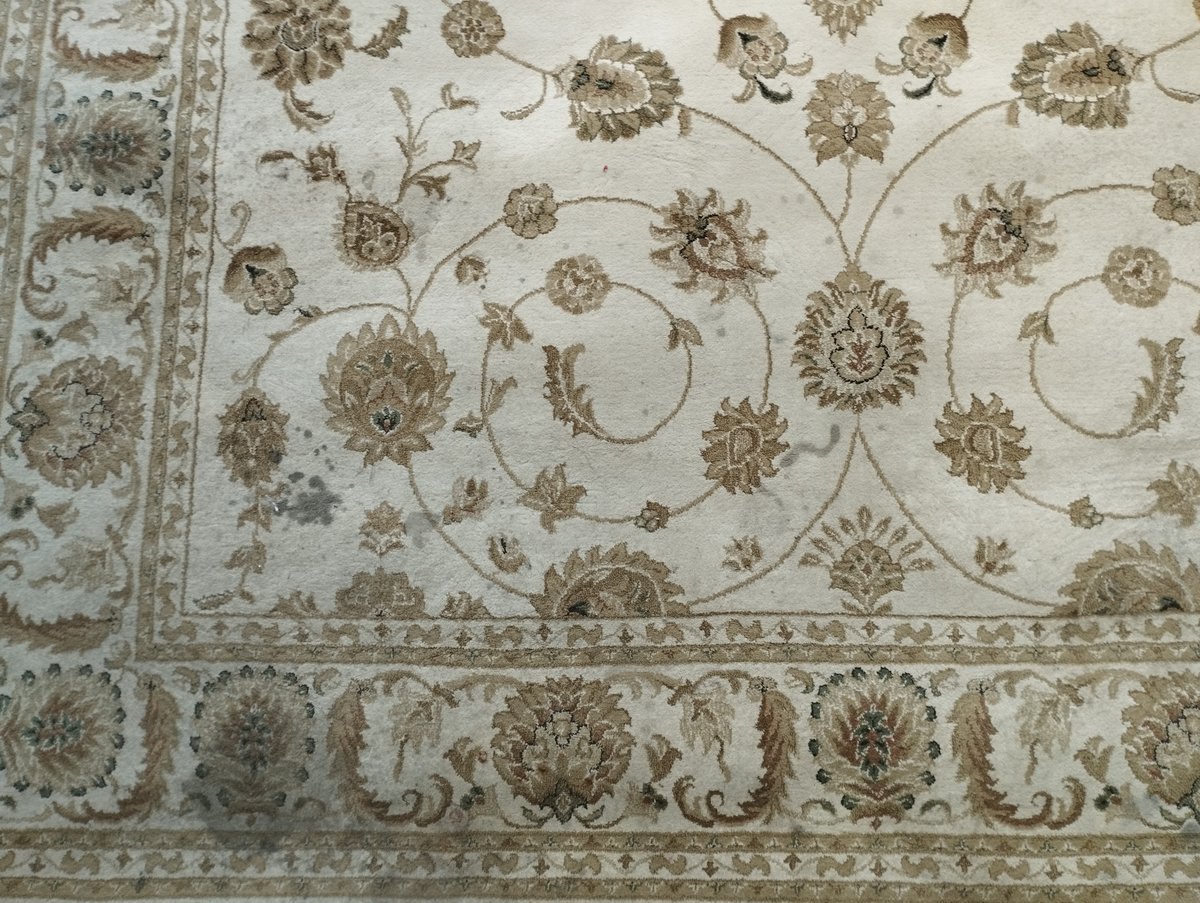 Alfombra persa clara con manchas, antes de la limpieza